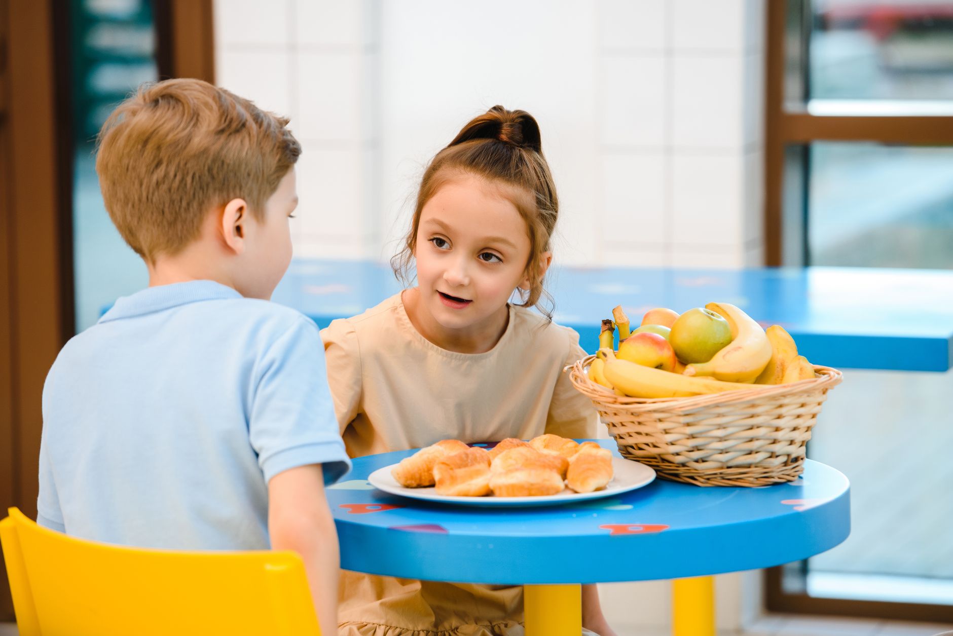Table de petit-déjeuner équilibré pour enfants avec bol de flocons d'avoine, fruits frais, pain complet et yaourt