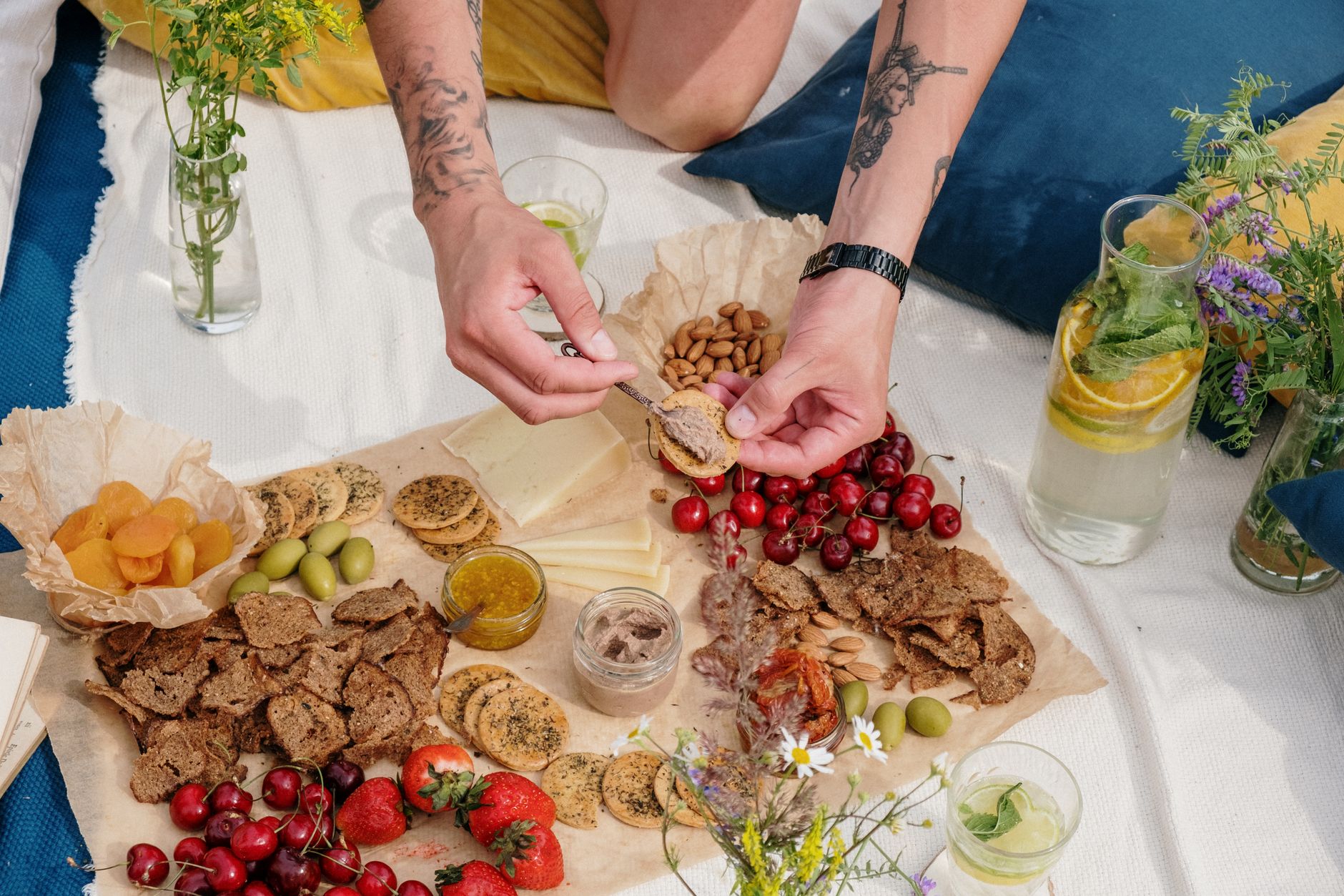Planche apéritif maison avec houmous, tapenades noire et verte, crackers aux graines et bâtonnets de légumes