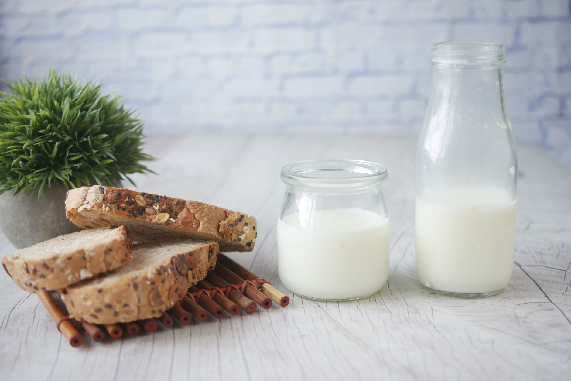 Bocal en verre de kéfir de lait maison et grains de kéfir sur une cuillère en bois