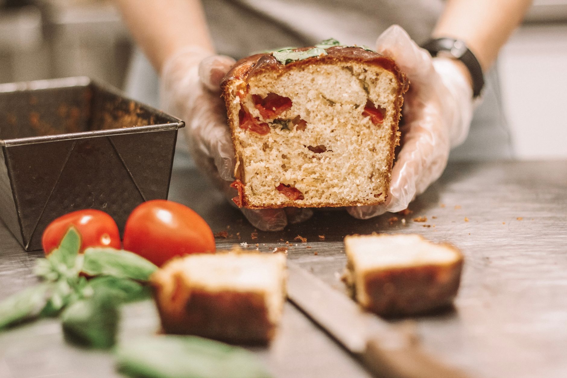 Cake salé maison tranché sur une planche en bois avec feta, olives et herbes fraîches