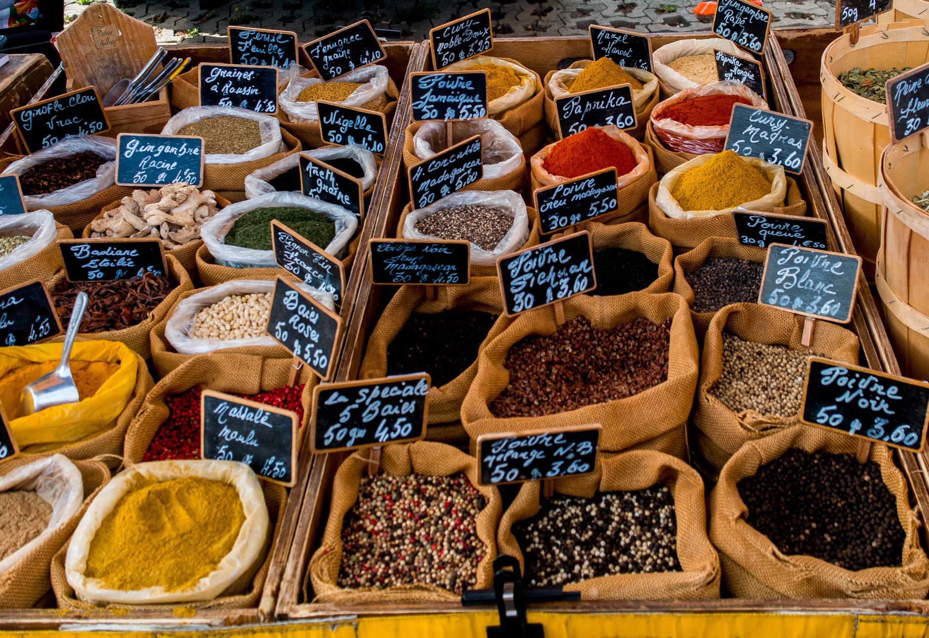 Assortiment d'épices et aromates du monde dans des petits bols en céramique sur un plan de travail en bois