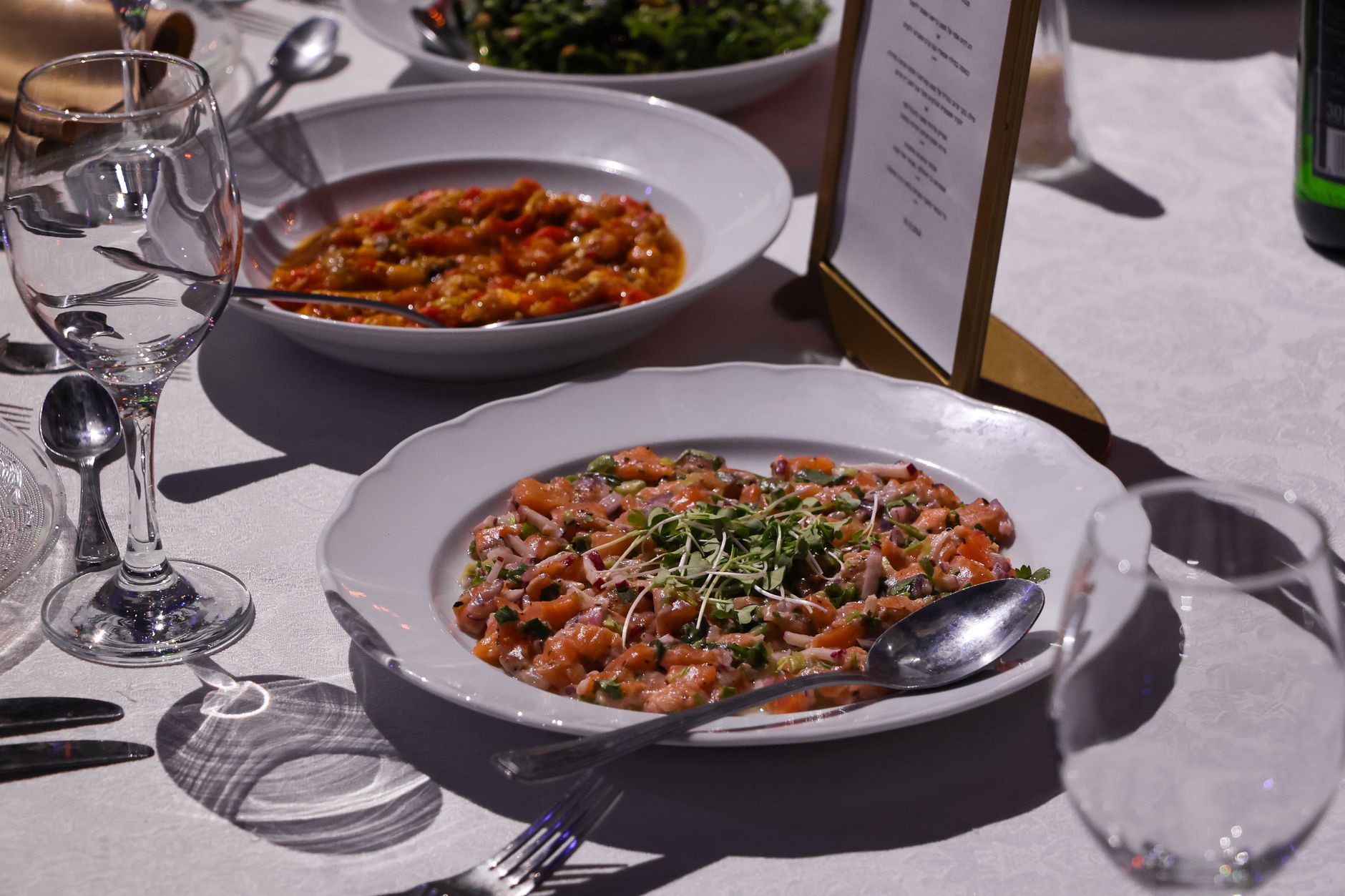 Table d'été avec un gaspacho de tomates, un tartare de légumes coloré et une salade fraîche aux herbes